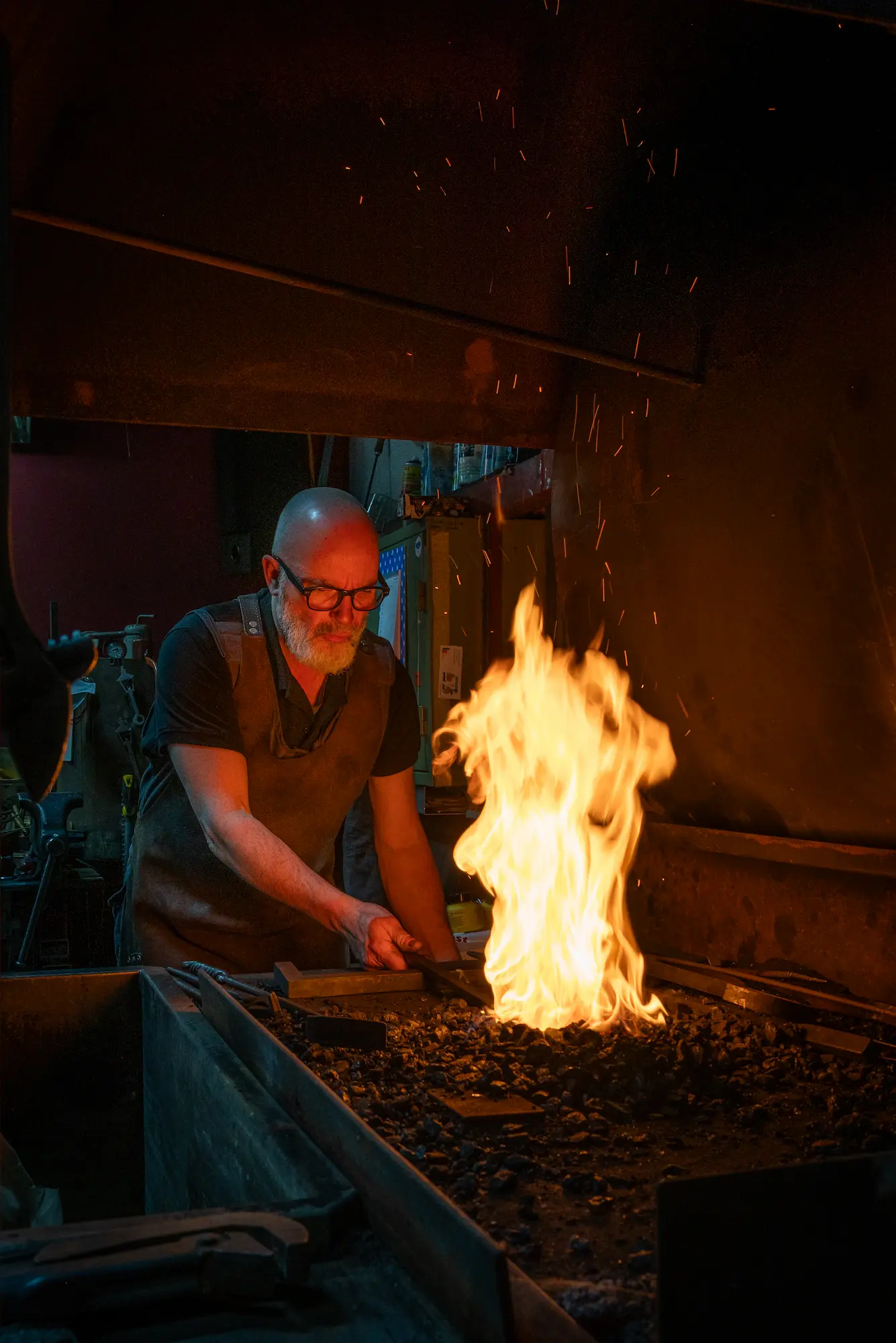 Een man met een baard en een bril bij een smitsvuur